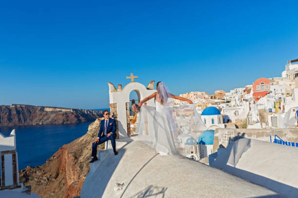 Wedding couple in Santorini Young wedding couple on the rooftops of Santorini, Greece happy couple on vacation in santorini greece stock pictures, royalty-free photos & images