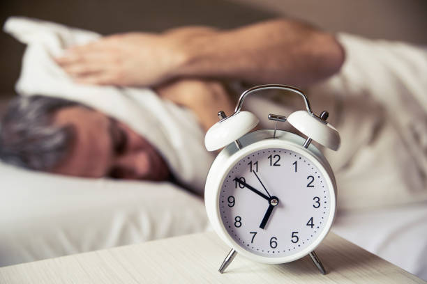 istock Frustrated man listening to his alarm clock 640098356