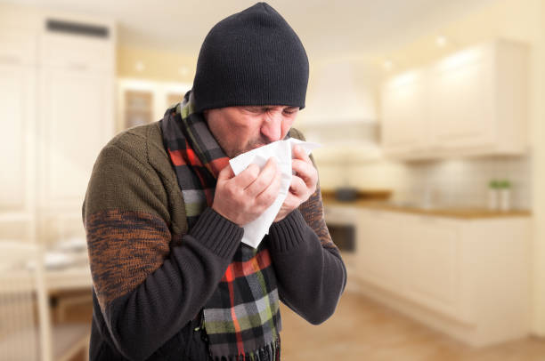 istock Young man sneezing into a handkerchief 640098964