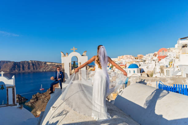 Wedding couple in Santorini Young wedding couple on the rooftops of Santorini, Greece happy couple on vacation in santorini greece stock pictures, royalty-free photos & images