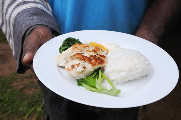 istock Indigenous Fijian man serve seafood and vegetables dish 640101154
