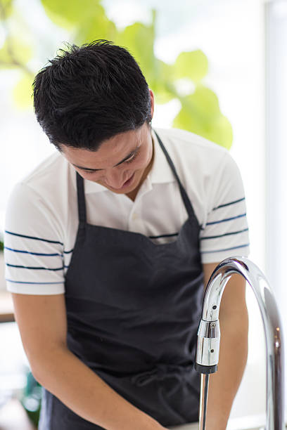 istock Bachelor at the sink washing dishes or vegetables 640101436