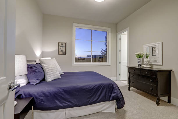 istock Beige and pale gray bedroom design accented with blue bed 640104854