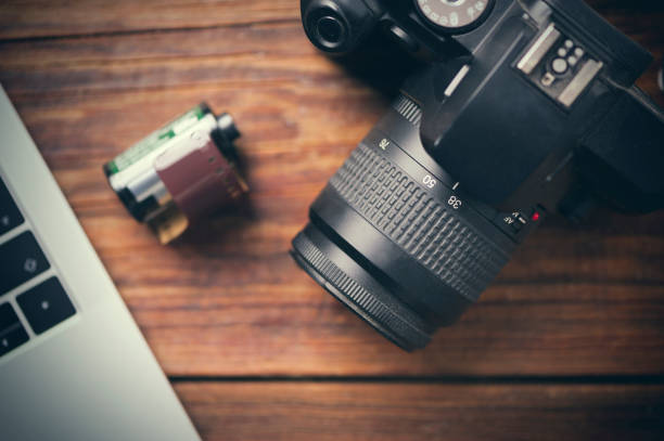 istock laptop and film camera on wooden table 640104898