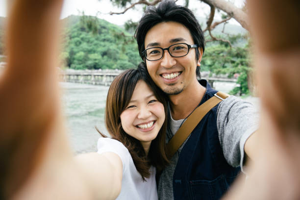 istock Cheerful Japanese couple taking selfie outdoors in a park 640105498
