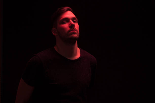 istock one man looking above up, looking at camera, red color 640106692