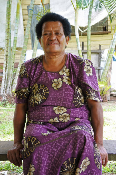 Elderly indigenous Fijian woman Elderly indigenous Fijian woman in her 70's sit outside her village home.  Real people copy space pacific islands stock pictures, royalty-free photos & images