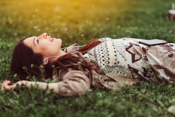 mulher sonhadora na grama - relaxation lying on back women meditating - fotografias e filmes do acervo