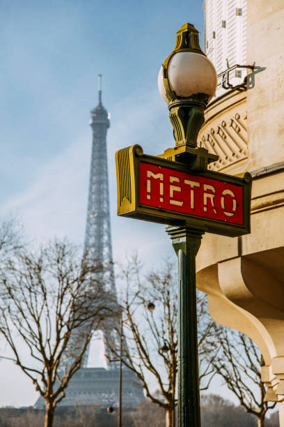 Paris Metro sign A Paris Metro sign, Eiffel Tower in the background. paris metro sign stock pictures, royalty-free photos & images