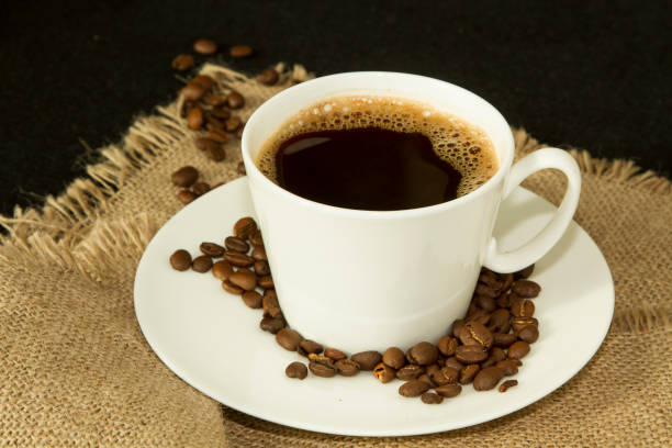 istock White cup of coffee with coffee beans on saucer on 640109448