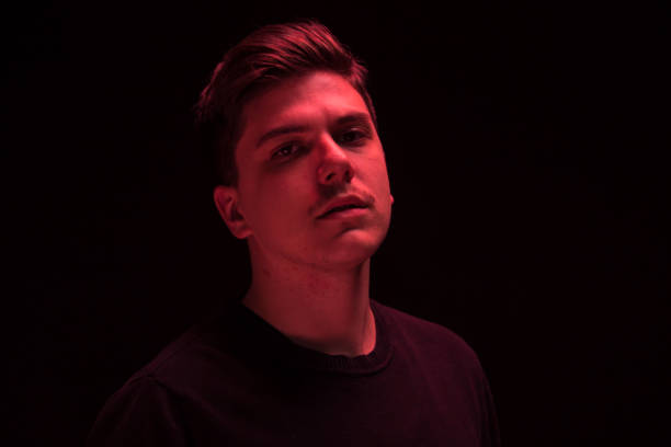 istock one man looking above up, red color light 640109476
