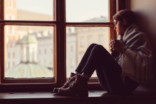 istock Depressed woman on the window 640109542