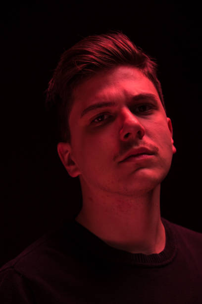 istock one man looking above up, red color light 640110046