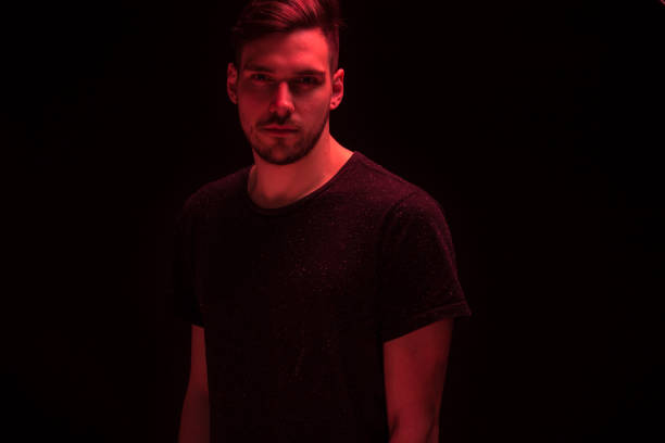 one young man looking at camera, red color light