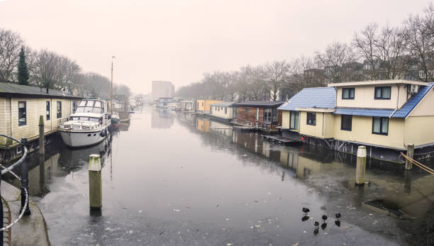 Traditional Dutch floating houses on freezing canal stock photo