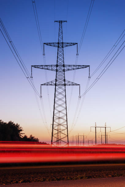 istock High voltage electricity pylon system and tracks from traffic. 640116370