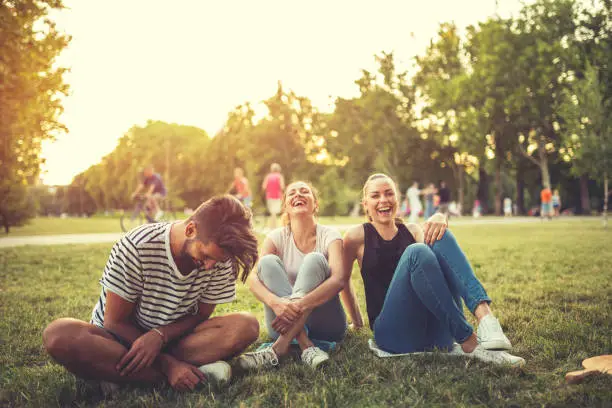 Three beautiful friends sitting in the park,laughing and having a great time