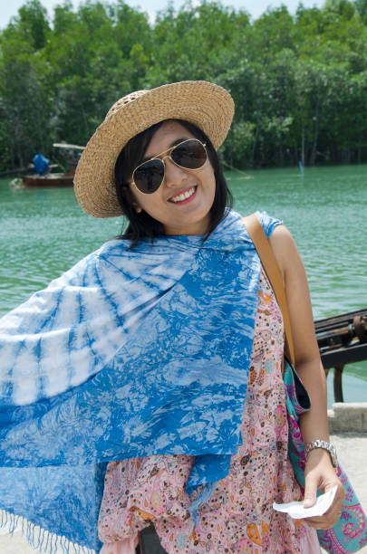 istock Thai women relax and playing indigo tie dye fabric shawl 640123374