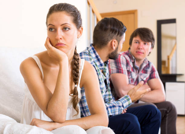 Quarrel among adult partners Two men quarreling over a woman at home menage trois stock pictures, royalty-free photos & images