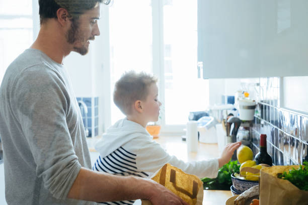 istock Father And Son Organizing Groceries In The Kitchen 640125946