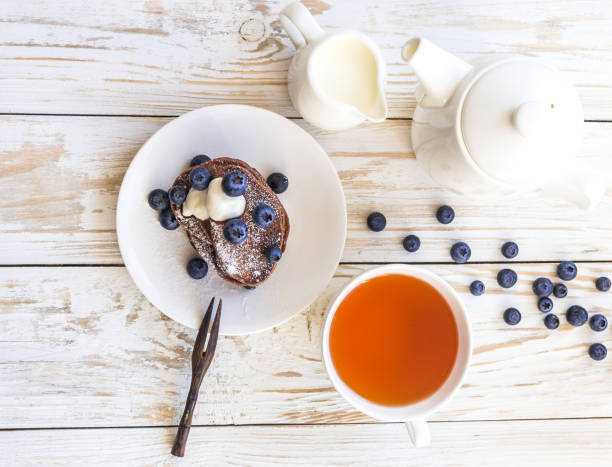 Hot tea and buckwheat chocolate pancakes with blueberries