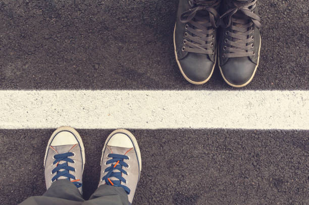 Two pair of sneakers on a asphapt road. stock photo