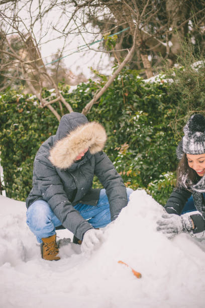 istock boy and girl playing with snow 640131226