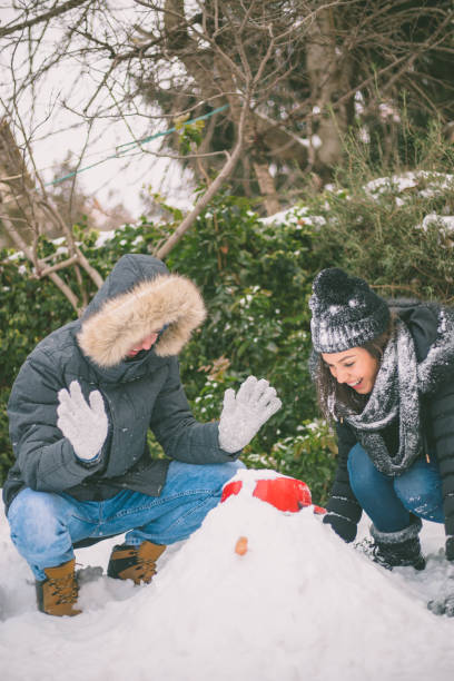 istock boy and girl playing with snow 640131260