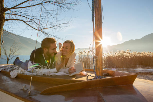 istock Young couple relaxing by the lake reading book 640134638