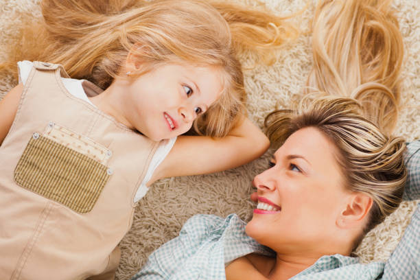 istock Mother and daughter lying on carpet and relaxing 640137406