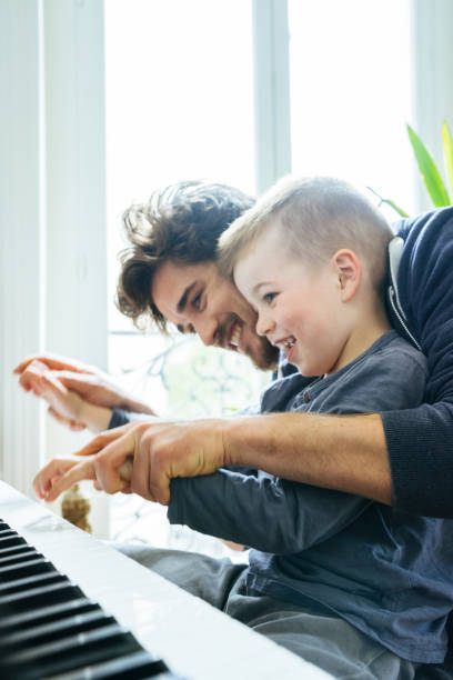 istock Father And Son Playing Piano Together At Home 640141866