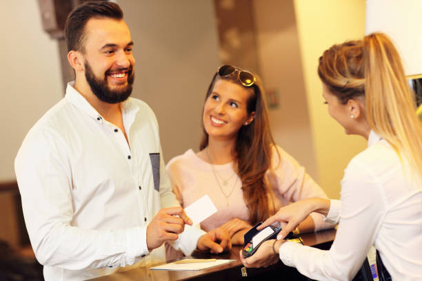 istock Couple at reception desk paying for hotel 640146322