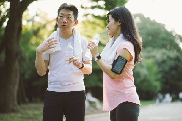 istock Cheerful Japanese friends relaxing outdoors in a park after workout 640146618
