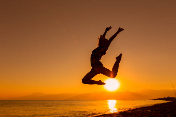 istock Silhouette of Young Women Jumping on beach 640146692