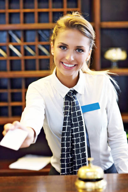 Pretty receptionist giving key card Picture of receptionist giving key card hotel reception hotel business lobby stock pictures, royalty-free photos & images