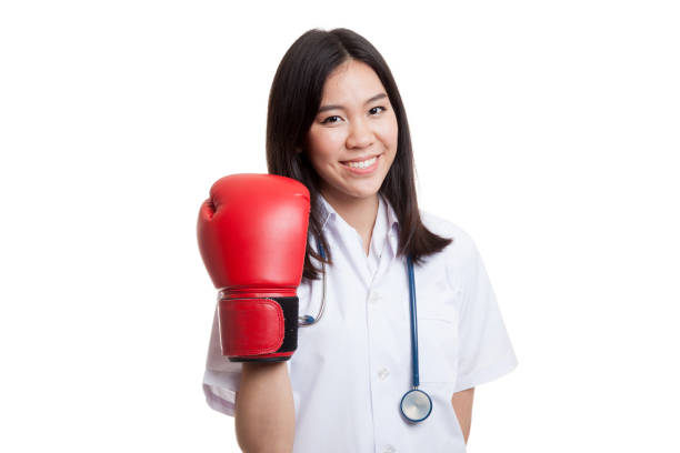 junge asiatische ärztin mit boxhandschuh. - fist women punching asian ethnicity stock-fotos und bilder