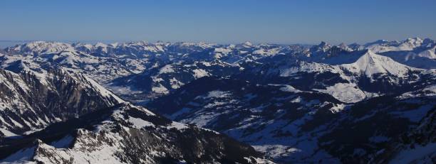 distant view of gstaad and snow covered mountains - bernese oberland gstaad winter snow imagens e fotografias de stock