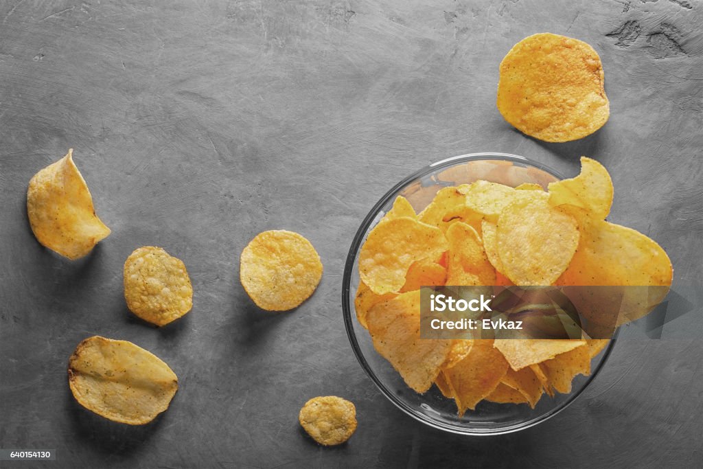 Potato chips in bowl with tomato juice in glass Potato Chip Stock Photo