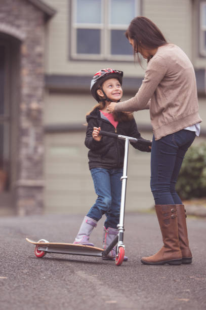 istock Mother putting a helmet on her daughter 640157138