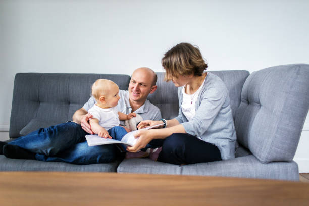 istock Parents reading a book together with a child 640159758