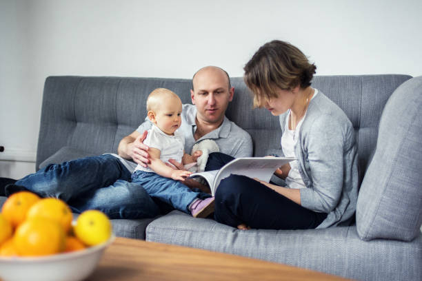 istock Parents reading a book together with a child 640159910