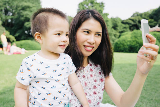istock Happy mother and son outdoors surfing the net on smartphone 640162146