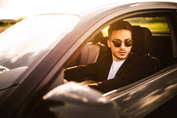 istock fashion man driving a black car 640163510