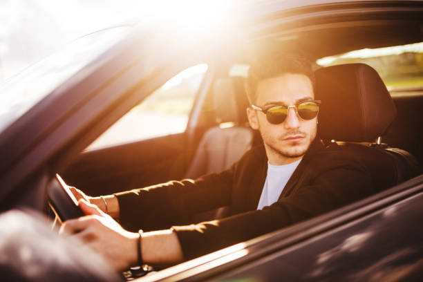 istock fashion man driving a black car 640163574