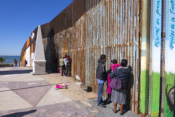 Playas de Tijuana, Mexico - January 28, 2017: Mexican families living in Tijuana visit with family members living in the United States by meeting at the border wall in Playas de Tijuana on a sunny winter Saturday morning.