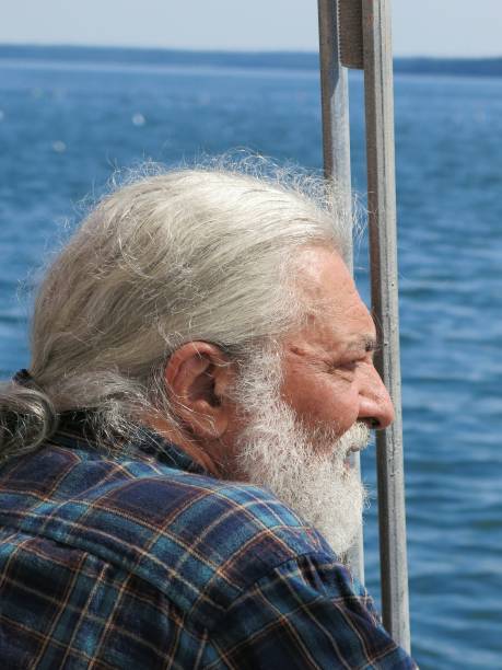 istock Gray Bearded Pony Tail Senior Hippie Enjoying Water View Boat 640171454