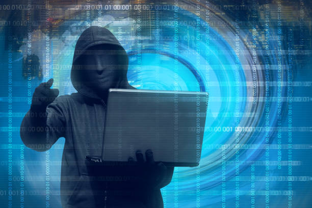 istock Hooded man with mask holding laptop 640172656