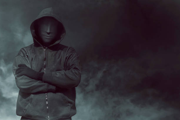 istock Hooded man with mask standing alone 640172712