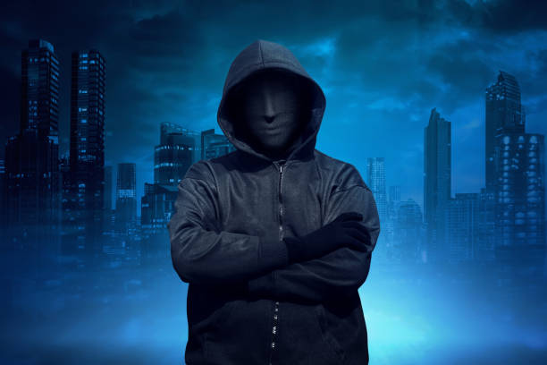 istock Hooded man with anonymous mask standing 640172804