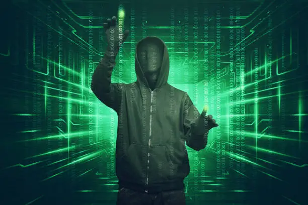 Hacker man with anonymous mask hacking binary system security code on the virtual screen